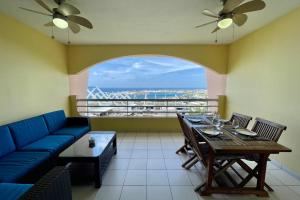 帕皮提Appartement Hana Iti breathtaking on the ocean at the entrance of Papeete的客厅配有蓝色的沙发和桌子