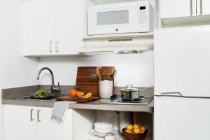 圣安东尼奥InTown Suites Extended Stay San Antonio TX - Perrin Beitel Road的白色的厨房配有水槽和微波炉