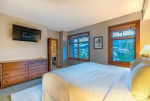 斯诺马斯村Capitol Peak Lodge by Snowmass Mountain Lodging的一间卧室设有一张床、一台电视和窗户。