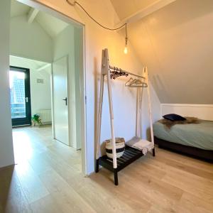 EwijkHuisje Hygge - luxe bungalow met grote tuin的一间带床和秋千的房间
