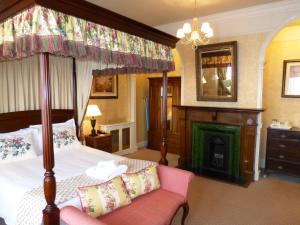 迪韦齐斯贝尔酒店 的一间卧室设有一张天蓬床和一个壁炉