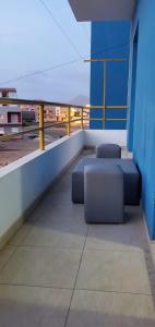埃斯帕戈斯Apartamento Teixeira的大楼内的阳台配有2个蓝色长椅