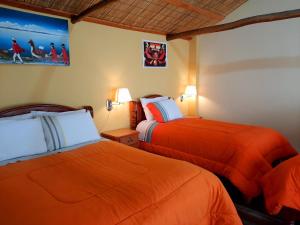 Comunidad YumaniWara Uta Lodge的配有橙色床单的酒店客房内的两张床