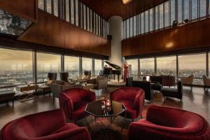 河内河内乐天酒店的酒店大堂设有红色椅子和钢琴