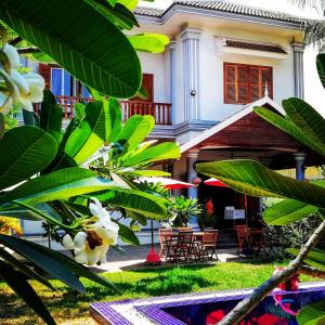 暹粒Villa b.Maison d'Hôtes Angkor的前面有绿色植物的房子