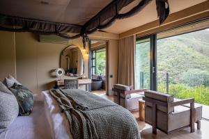 Reebok波特里尔斯科普私人野生动物保护区酒店的一间卧室设有一张大床和一个大窗户