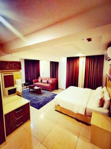 锡卜Diamond Star Hotel فندق النجمة الماسية的一间卧室设有一张床和一间客厅。
