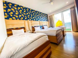 古尔冈Sky Suites的酒店客房设有两张床和窗户。