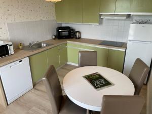 普雷讷夫昂德雷KER LOÏS Grand appartement Vue Mer tout confort的厨房配有白色桌子和白色冰箱。