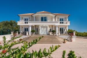 阿克罗蒂Frido Luxury Villa with Jacuzzi的一座白色的大房子,有楼梯和植物