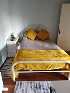 布拉加Quinta dos Campos - Apartamento 2的卧室内的一张带黄色毯子和枕头的床
