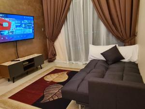 新山Eid SKS Habitat -Free Wifi Netflix, Larkin, Johor Bahru的带沙发和平面电视的客厅