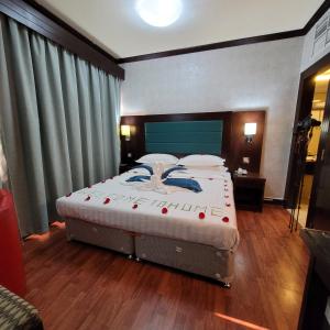 阿布扎比斯特朗德酒店的一间卧室配有带白色床单和枕头的床。