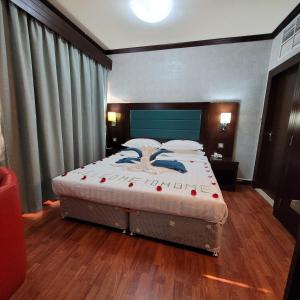 阿布扎比斯特朗德酒店的一间卧室配有一张大床和蓝色床头板