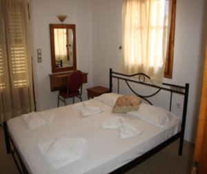巴利恩季米特里斯公寓 的一间卧室配有一张带白色床单和镜子的床
