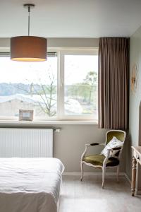 Rijkevorsel图茵德兹嫩住宿加早餐旅馆的卧室配有床、椅子和窗户。