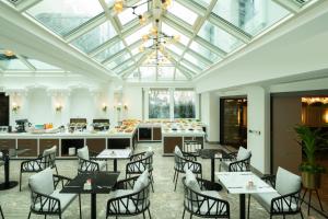 伊斯坦布尔妮娜酒店的一间带桌椅和玻璃天花板的用餐室