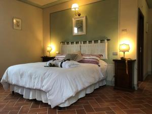 阿雷佐拉坎婷娜热赖斯赛普拉斯农家乐的一间卧室配有一张带两盏灯的大型白色床。
