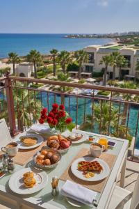 迦玛特突尼斯四季酒店的一张桌子,在阳台上提供早餐食物,阳台上享有海景