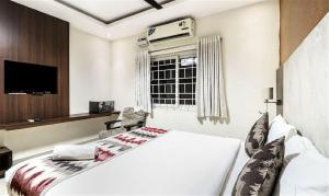 钦奈StayEasy Tiruvanmiyur (Unit of Prohotel)的卧室配有白色的床和窗户。