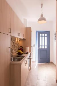 SifnosBLUE Seaside Studio的厨房配有木制橱柜和蓝色门