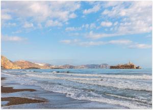 胡塞马Radisson Blu Residences Al Hoceima的海水中波浪和岩石的海滩