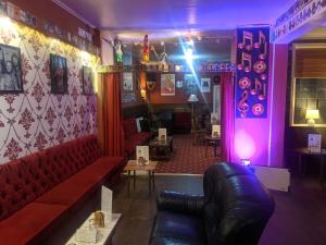 布莱克浦The Albert Hotel Near Winter Gardens的一间酒吧,配有红色的沙发,一间紫色的房间
