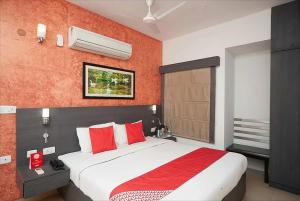 钦奈StayEasy Tiruvanmiyur (Unit of Prohotel)的卧室配有带红色枕头的大型白色床