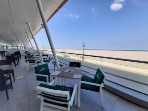 马马亚Zenith - Top Country Line - Conference & Spa Hotel的一间带桌椅和海滩的餐厅