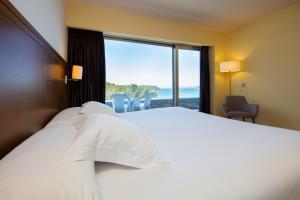 比韦罗Hotel Thalasso Cantabrico Las Sirenas 4 Superior的酒店客房设有一张床和一个大窗户