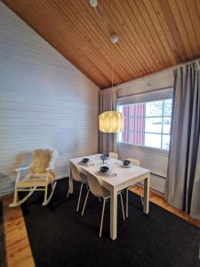 萨利色尔卡Winter Nest - A cozy accommodation in the heart of Saariselkä的一间设有白色桌子和窗户的用餐室