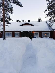 萨利色尔卡Winter Nest - A cozy accommodation in the heart of Saariselkä的雪覆盖的房屋,车道