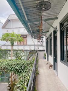 大叻Da Lat Lemongrass - Đà Lạt Sả的建筑中带遮阳篷和植物的阳台