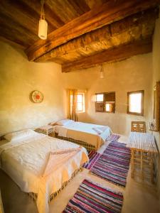 锡瓦Sleep In Siwa的一间带三张床和地毯的卧室