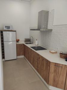 拜纳APARTAMENTO TURISTICO LEO BAENA的厨房配有木制橱柜和白色冰箱。