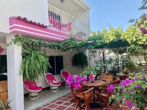 圣玛尔塔Casa Hospedaje Villaluz- a 5 minutos de la Playa的庭院配有桌椅和鲜花