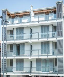 米兰阿尔法比可卡公寓 的带阳台和街灯的白色公寓大楼