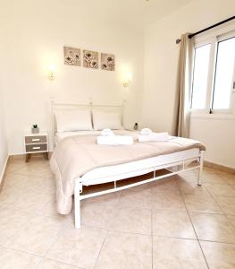 卡尔帕索斯Avra Rooms的卧室配有白色的床和窗户。