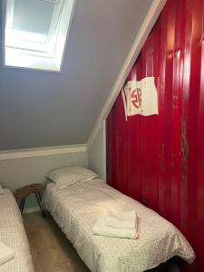 奥拉涅沃德Tiny-House van zeecontainers bij het bos的红色墙壁的客房内的两张床