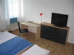 塞尔比茨Gasthof-Pension Leupold的一间卧室配有一张桌子、一台电视和一张床
