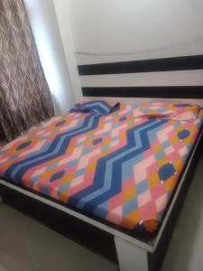 帕坦科特Sai Guest House的床上有五颜六色的被子