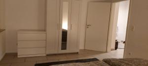 比特堡Ferienwohnung KaMa的卧室配有白色橱柜和镜子