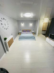 克里沃罗格Студия LUX в центре города的卧室配有一张床,墙上挂着一个钟