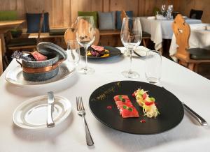 利维尼奥拉克萨林温泉山区度假酒店的一张桌子,上面放着两盘食物和酒杯