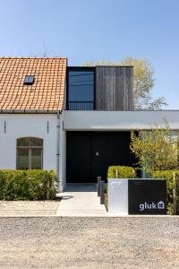 佐内贝克GLUK的白色的房子,设有黑色车库