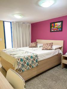 特雷西纳Executivo Prime Hotel的一间卧室配有一张大床和紫色墙壁