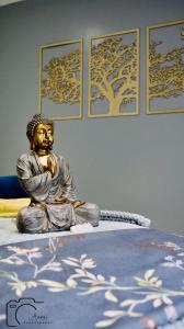 CoteCripps Farm Holiday Lets的坐在床上的佛陀雕像