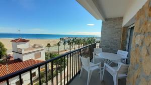 托里代巴拉Apartamentos Dins Mar Apto. 10的一个带桌椅和海滩的阳台