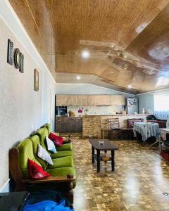 UdabnoMamuka's Guesthouse的客厅配有绿色沙发和桌子