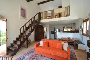 奥皮约Le Mas sous le Vent的客厅配有橙色沙发和楼梯